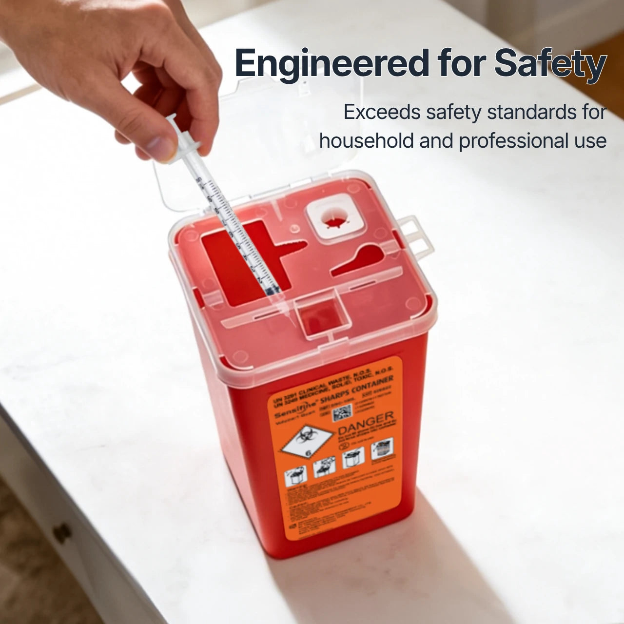 Red sharps container with a hand holding a syringe, labeled 'Engineered for Safety' on a white surface.